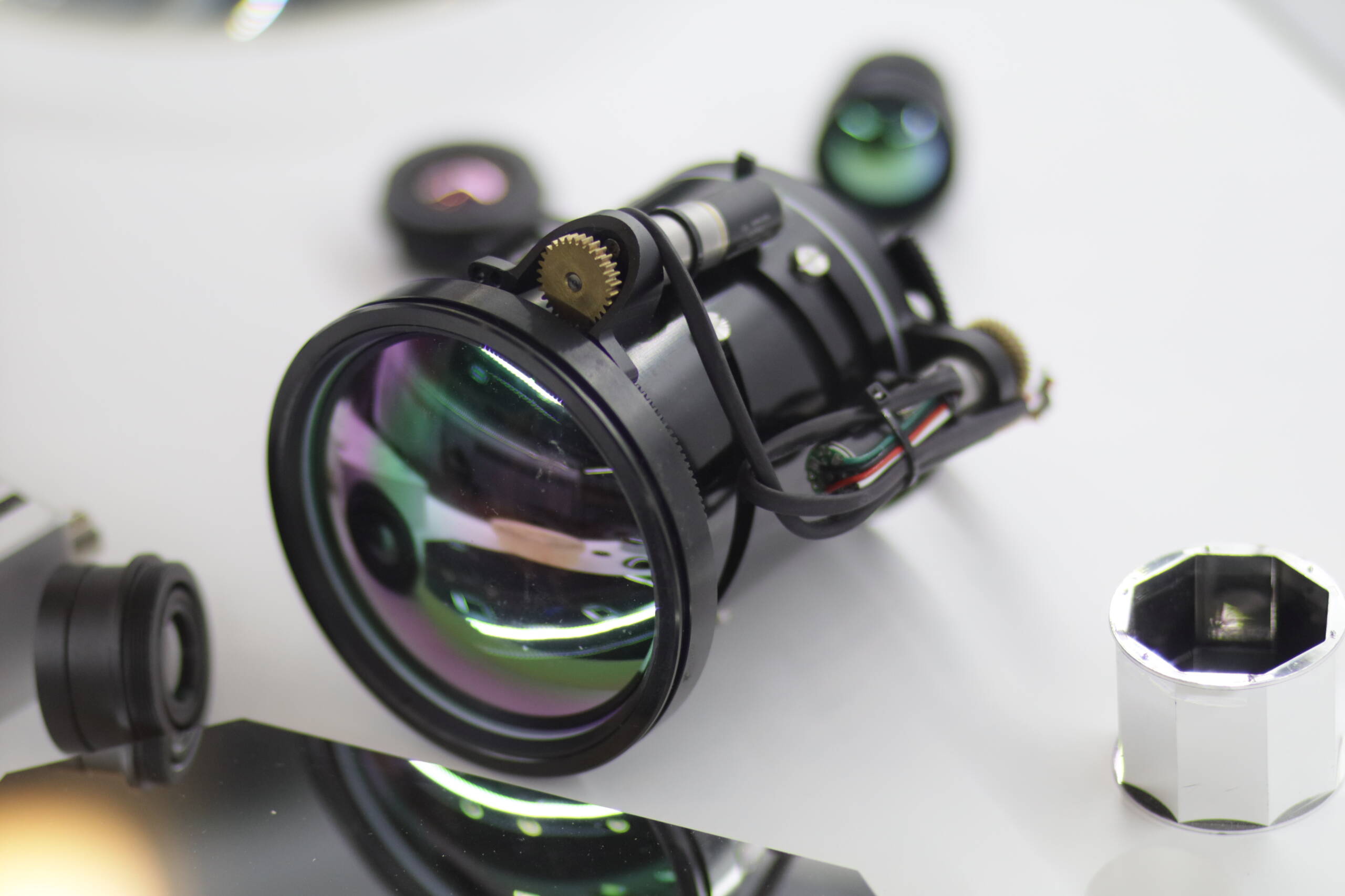 Disassembled lens showing internal optics, gear-driven focus mechanism, and wiring